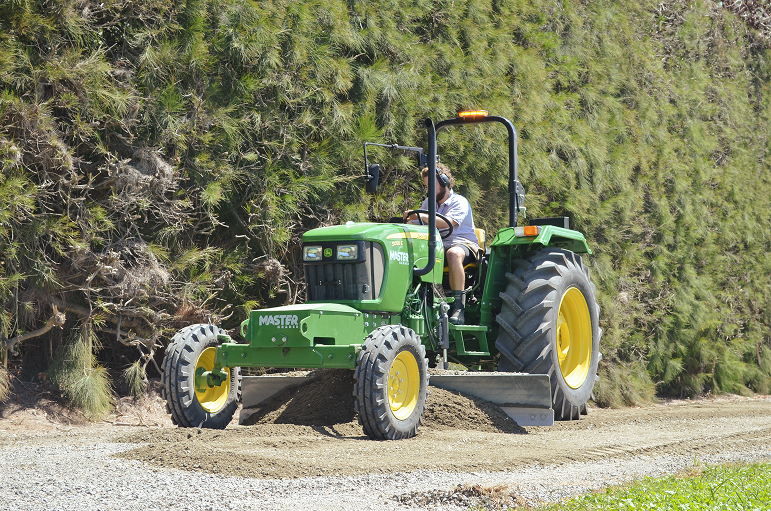 Worker using GradeMaster on dirt road